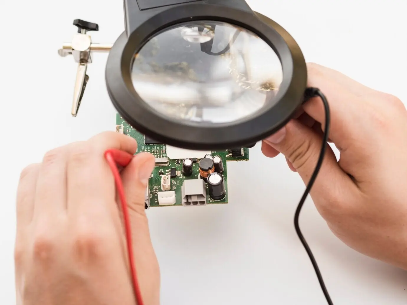 Ein Mann verwendet ein Multimeter, um eine Platine zu überprüfen.